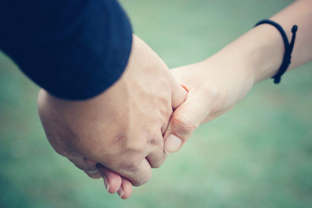 Two people hold each other's hand.