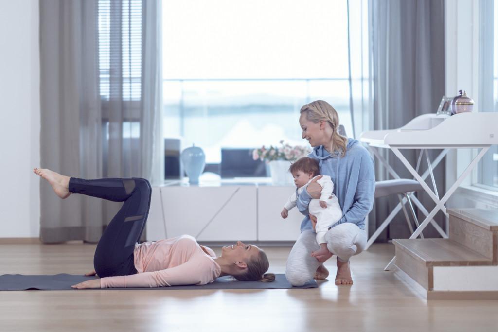 Two women doing workout with a baby.