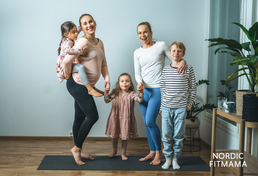 Two adults and three children posing for a camera.